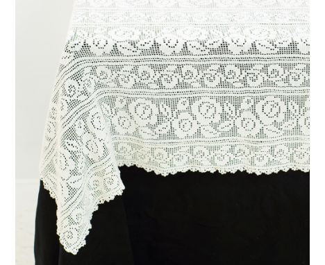 An old hand crocheted tablecloth, white with stripes filled with roses measuring 140x240cm. With minor stains. Mid 20th centu
