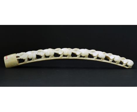 An African carved ivory tusk with a train of seven elephants. L57cm, approx. weight: 659g, early 20th century, with CITES Cer