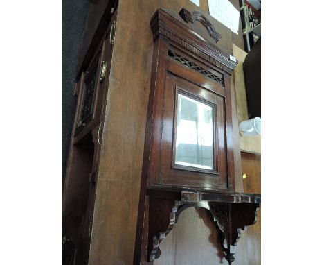 A late Victorian mahogany hall mirror having crest and fret decoration and shelf under