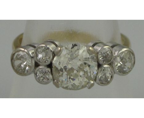 A VICTORIAN DIAMOND CLUSTER RING the central cushion cut diamond having three collet set diamonds to either side. Estimated t