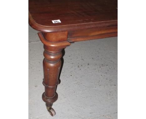 20TH CENTURY MAHOGANY RECTANGULAR SHAPED EXTENDING DINING TABLE with moulded top on fluted turned tapering legs with brass cu