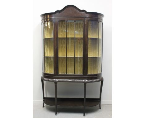 20TH CENTURY MAHOGANY BOW FRONTED CHINA DISPLAY CABINET, having moulded arched pediment above centred drawer with two fitted 