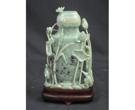 CHINESE MID GREEN CARVED JADE, URN SHAPED, LIDDED VASE overall with grey and black flecks, the cover with relief carved flowe