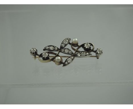 A VICTORIAN DIAMOND AND PEARL SET BROOCH.  The naturalistic design depicting scrolling leaves and berries set with old cut di