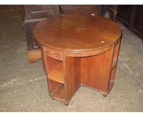 EARLY 20TH CENTURY OAK CIRCULAR 'HEAL & SON' LIBRARY TABLE, the moulded edge top on a cruciform base with open shelves standi