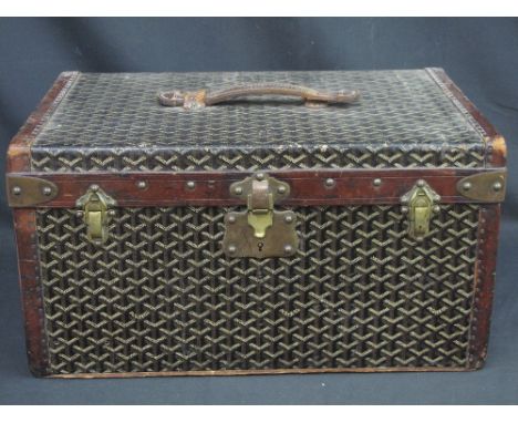 A SMALL FRENCH GOYARD LEATHER BOUND TRAVELLING TRUNK having overall print finish with leather handle and edgings, brass corne