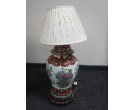 A Chinese floral pottery table lamp with shade on wooden base 