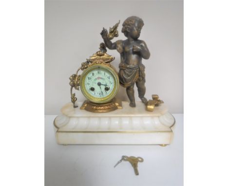 A continental gilt figural mantel clock of a cherub with enamelled dial on marble base 