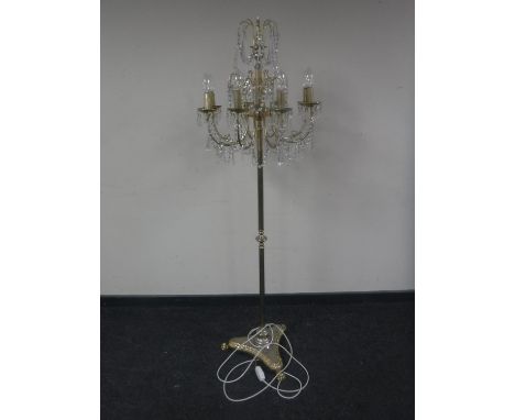 A brass eight way floor lamp with glass drops 