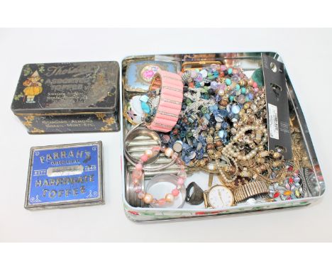 A tin containing two silver napkin rings, costume jewellery, cigarette case, trinket boxes, two vintage tins, military cap ba