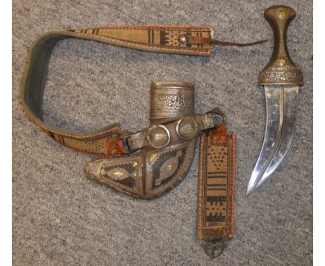 AN ARAB JAMBIYA, 20TH CENTURY with curved medially-ridged blade, horn hilt profusely studded with iron nails, embossed silver