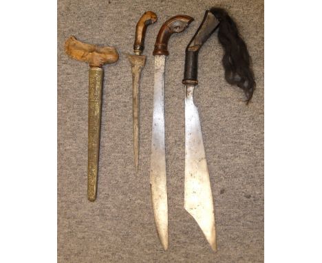 THREE SOUTH EAST ASIAN DAGGERS, 19TH/20TH CENTURIES comprising a Malaysian keris, with pattern welded blade, carved hardwood 