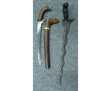A SUMATRAN KERIS AND A CELEBES DAGGER, LATE 19TH/20TH CENTURY the first with wavy pattern-welded blade, and carved hardwood f