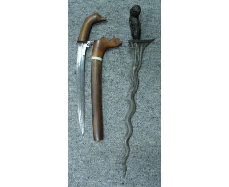 A SUMATRAN KERIS AND A CELEBES DAGGER, LATE 19TH/20TH CENTURY the first with wavy pattern-welded blade, and carved hardwood f