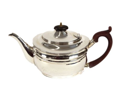 An Edwardian silver teapot, of oval form with reeded band decoration, wooden handle and lift, London 1904, 16ozs. gross