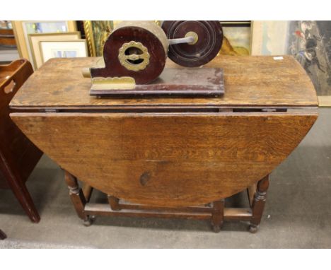 An Antique oak gate leg dining table, raised on baluster turned supports terminating in club feet, 107cm wide