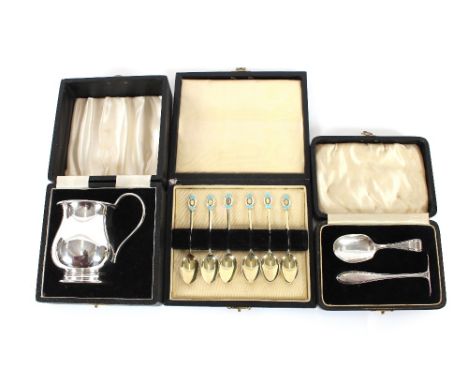 A cased set of silver gilt and enamel decorated coffee spoons; a cased silver pusher and spoon; and a plated Christening tank