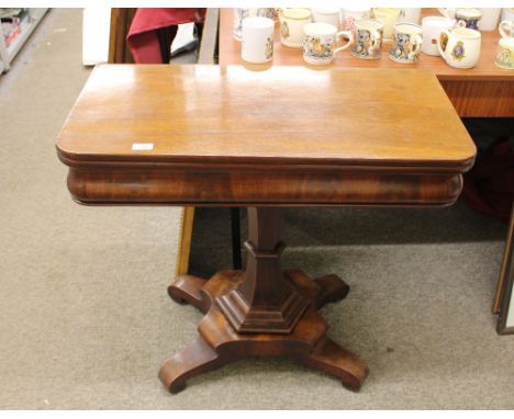 A Victorian mahogany card table, the rectangular foldover swivel top raised on octagonal column and quatrefoil&nbsp; base, te