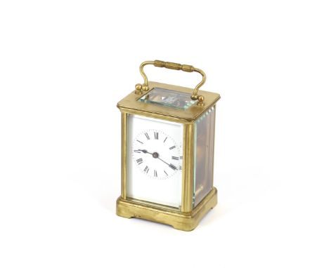 A brass cased carriage timepiece, having white enamel Roman numeral dial, angular swing handle, 16cm high overall
