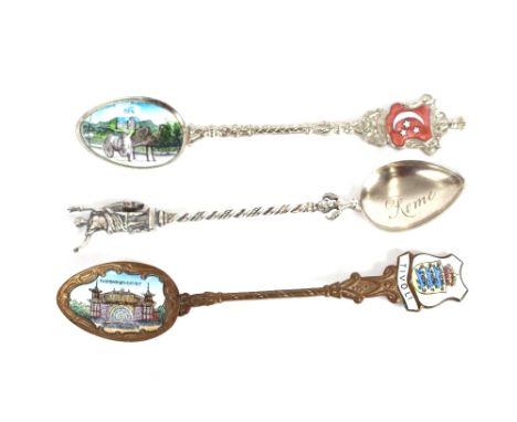 A Continental white metal spoon, with figural decorated stem, the bowl embossed with buildings and inscription; and two Conti