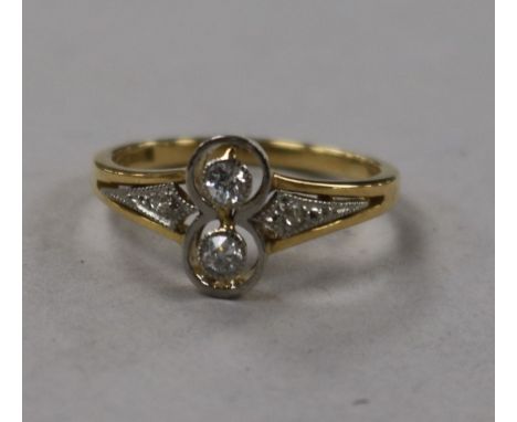 A 20th century 18ct gold and two stone diamond ring with diamond set shoulders, size K.