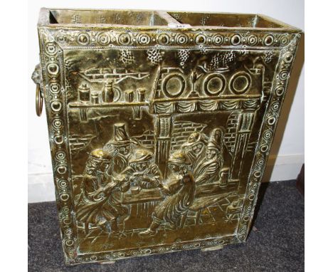 An early 20th century highly polished brass stick stand,  embossed in relief with tavern scene, two lion mask and loop handle