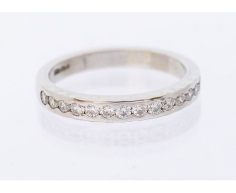 A diamond and platinum half eternity ring, comprising a a row of fourteen flush set round brilliant cut diamonds, total diamo