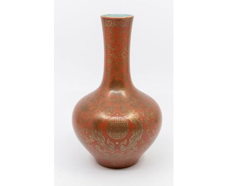 A Chinese Qianlong bottle vase, the red ground decorated with Chinese circle motifs within profuse flowers and foliage, red s