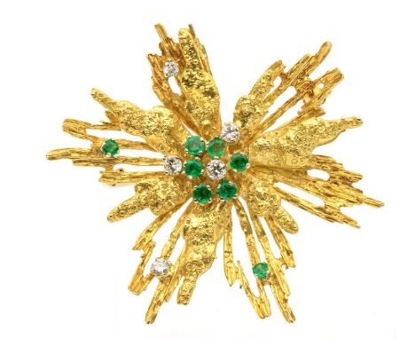 A stylized diamond and emerald brooch, circa 1970s, comprising a textured floral form set to the centre with a cluster of rou