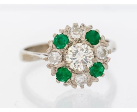 An emerald and diamond 18ct white gold cluster ring, comprising a central round brilliant cut diamond approx 0.55ct, assessed