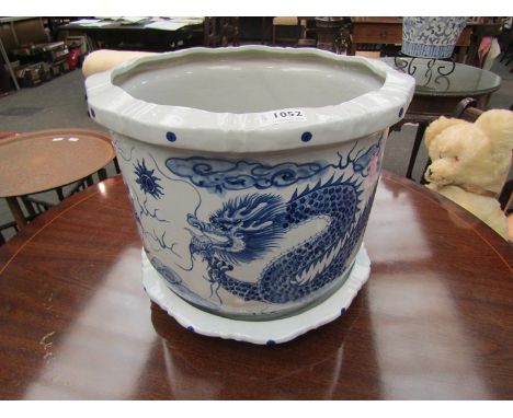 A blue and white ceramic jardiniere with dragon pattern, with saucer, 31cm tall, 38cm diameter