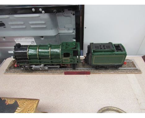 A painted wooden model steam engine on track