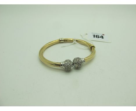 A Modern Hinged Bangle, of twisted design with inset highlights (sprung hinge), stamped "9kt" (overall weight 13grams). 