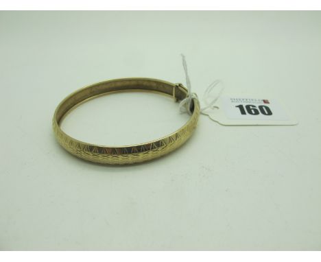 An Expanding Bangle, with geometric engraved decoration, stamped "375" (6.5grams). 