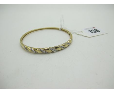  A Modern 9ct Gold Diamond Set Hinged Bangle, illusion set to the front, hinged to snap clasp, stamped "0.15" (9grams). 