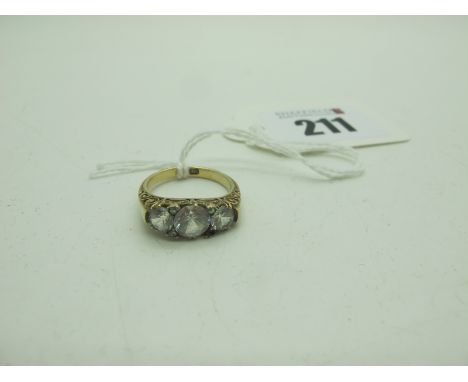 A Three Stone Dress Ring, within scroll carved setting, stamped "18" (finger size K) (4grams). 