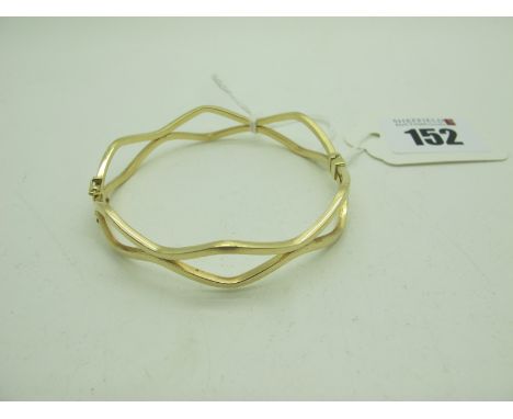 A Modern Hinged Bangle, of wavy design, stamped "14K" (6grams). 