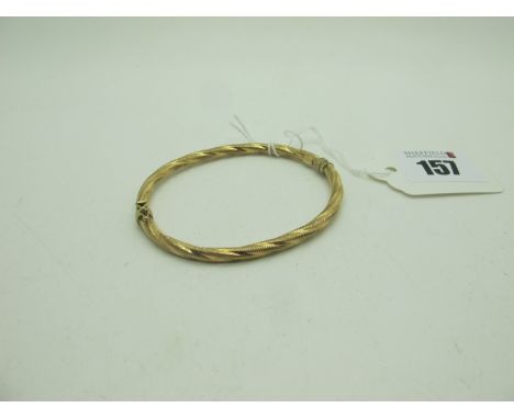 A Decorative Hinged Bangle, allover textured finish (sprung hinge) stamped "375" (3.8grams). 