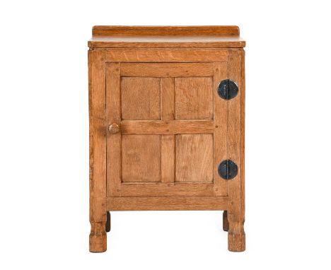 Robert Mouseman Thompson (1876-1955): An English Oak Bedside Cupboard, with raised upstand, above a door, enclosing a shelf, 