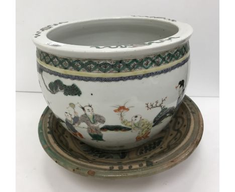A 19th Century Chinese Kangxi palette jardiniere decorated with figures playing with various games in a garden setting raised
