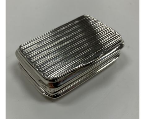 A 19th Century silver snuff box of fluted / reeded rectangular form with waisted sides, opening to reveal a gilt-washed inter