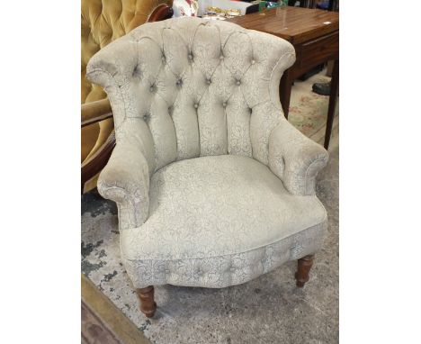 AN UPHOLSTERED BUTTON BACK ARMCHAIR
