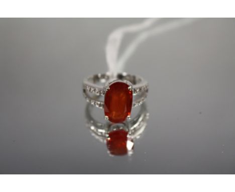 AN 18 CARAT WHITE GOLD FIRE OPAL AND DIAMOND RING, set with a Mexican Fire opal type central stone of an estimated 5 carats, 