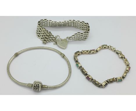 A silver gate bracelet and two other bracelets