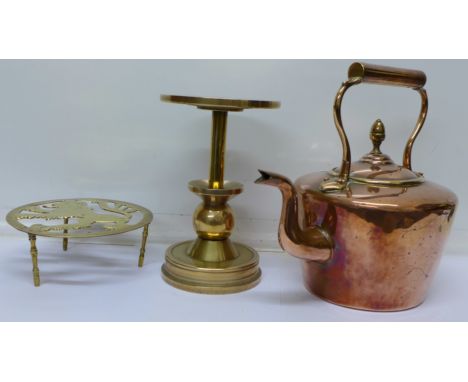 A copper kettle, a brass trivet and a heavy bronze trivet or stand