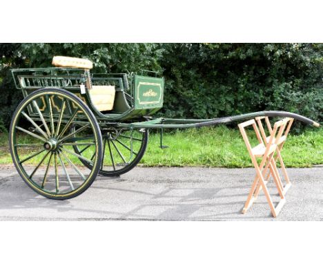 A Whitechapel-style rustic dog cart with a tan leather button back support and seat, repainted in green with yellow detail, r