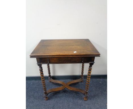 An Edwardian oak turn over top table fitted a drawer on bobbin legs 