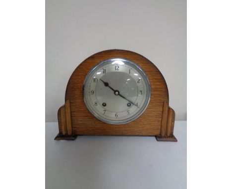 A 1930s oak cased Garrard mantel clock with silvered dial, pendulum and key.   