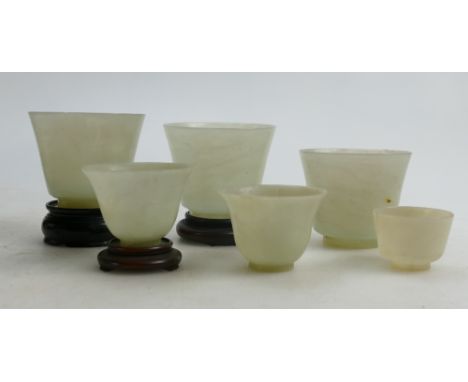 A collection of six Jade Beakers in varying sizes: Three of which have hardwood stands, height of tallest 6cm. (6) 