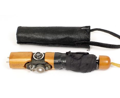 Umbrella Spy Camera. F-21 AJAX-12 spy camera with f2.8 28mm lens, hidden inside a man's umbrella. Raising the outer cover rev